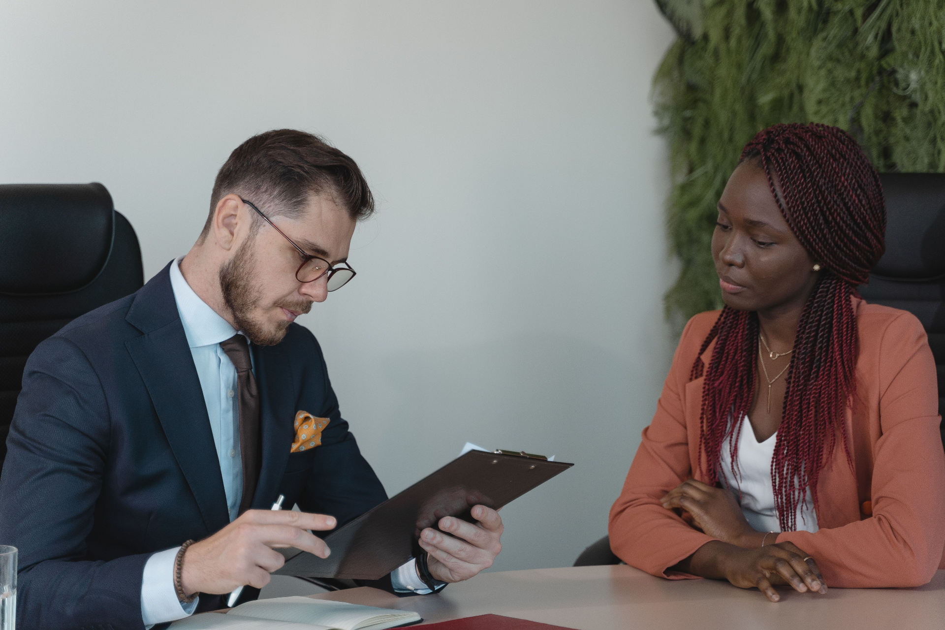 Adviser reviewing documents with a student across a desk.